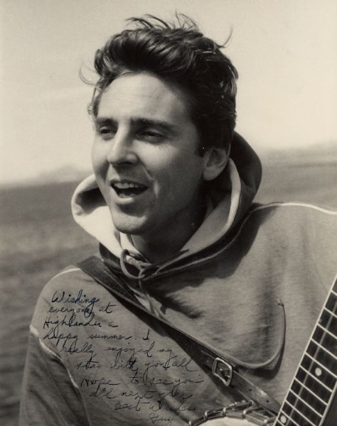 Signed photograph of Guy Carawan, a folk musician, playing an open-backed 5-string banjo.  Presented to Highlander Folk School.  Inscription reads, "Wishing everyone at Highlander a happy summer.  I really enjoyed my stay with you all.  Hope to see you all next year. Best Wishes, Guy."