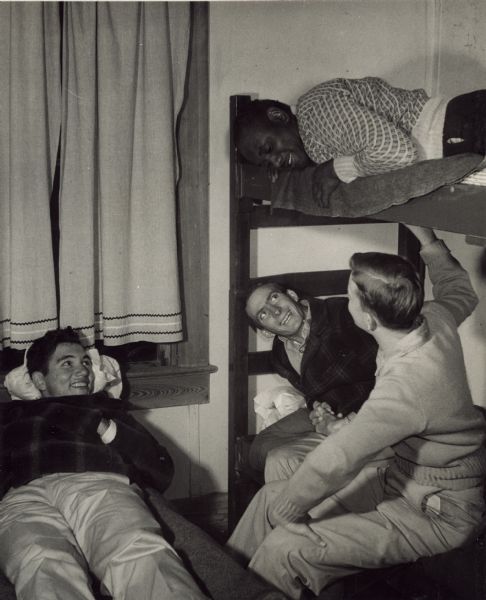 Members of a Farmers Union workshop at Highlander Folk School are seen relaxing in the men's dormitories on bunk beds.