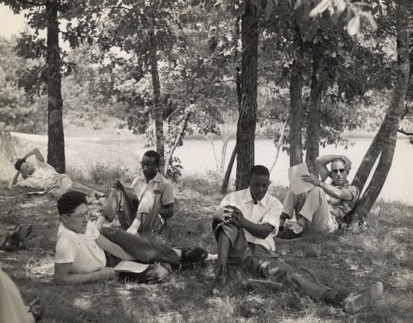 Mine, Mill & Smelters Union reading by a lake at Highlander Folk School.  Will Thomas, second on the right, smoking a pipe.