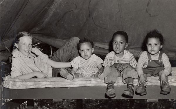 Young girl with children in tent.