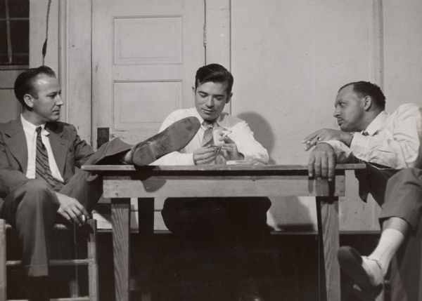 Three men smoking cigarettes around a table, as part of a CIO meeting at Highlander Folk School.