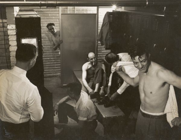 A group of men, one smoking a cigarette, in the men's locker room at Highlander Folk School.