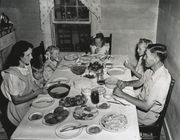A farming family, members of the Farmers Union, sharing a large dinner together.