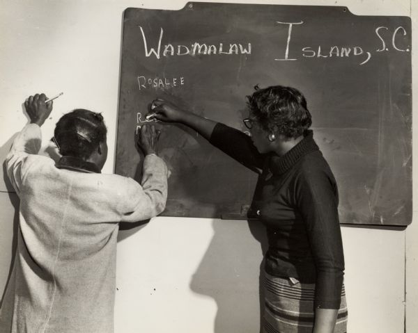 Two women at the blackboard during a Wadmalaw Island citizenship group evening class.