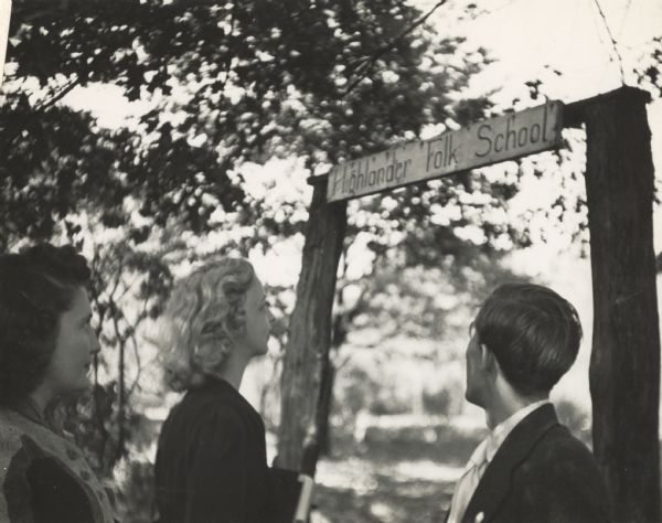 A group of early Highlander Folk School students standing near the entrance sign.