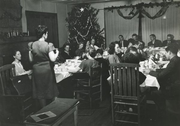 Zilphia Horton leading singing at CIO School during Holiday season. At the table on the right, Myles Horton, Mike Ross, Tom Ludwig, and Joyce Mitchell.