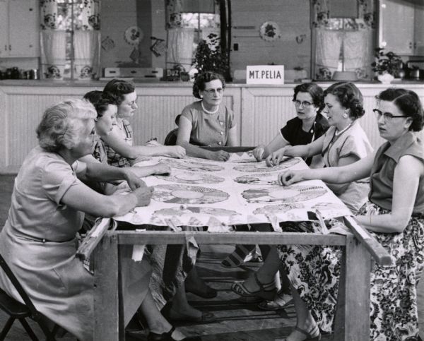 Farmers Union ladies quilting.  A sign in the background reads, "Mt. Pelia". In Weakley County.