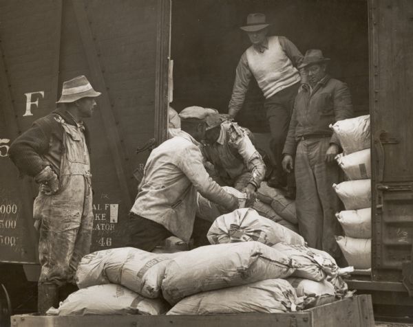 Members of the South Alabama Fertilizer Coop loading bags of fertilizer into a train car.