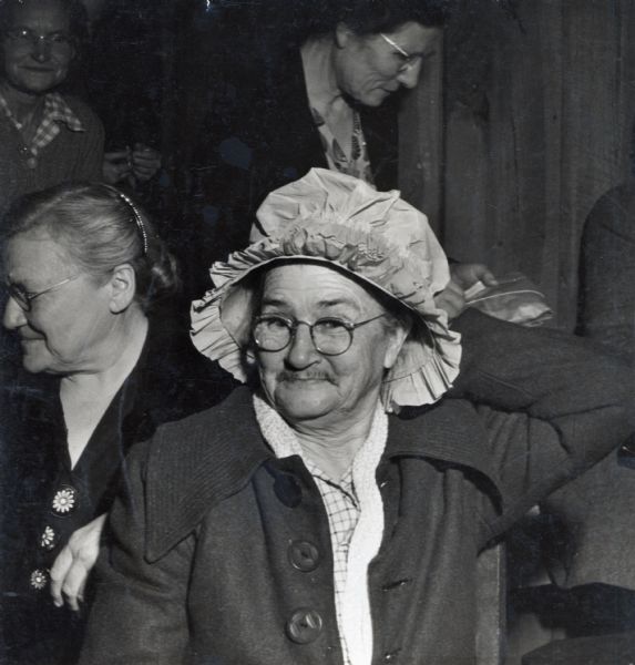 A man dressed as an old woman, possibly as part of a role playing activity.