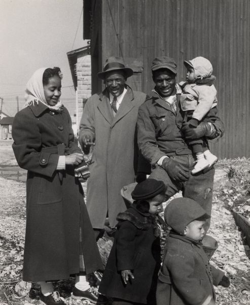 An African American family, with three children, dressed for cold weather.