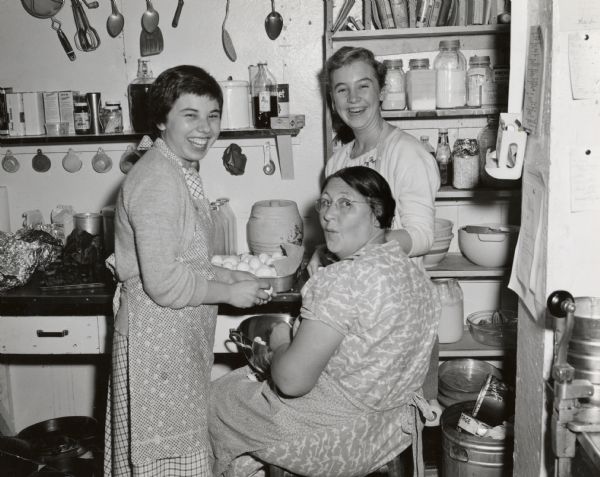 A group of women working on hard boiled eggs in the Highlander kitchen. Betty Shipherd on right, Antioch student on left.