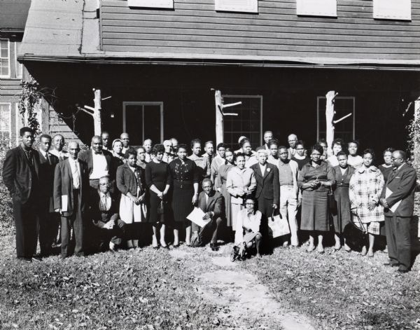 An unidentified group of people standing outside the main Highlander building. Esau Jenkins, fifth from left.