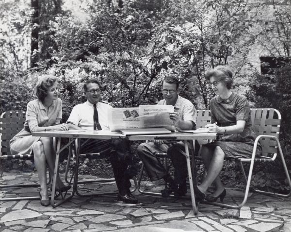 Staff meeting at Highlander Center in Knoxville, left to right: Aimee Horton, Myles Horton, Conrad Browne, Ora Browne.  Conrad is reading "The Carolina Israelite".