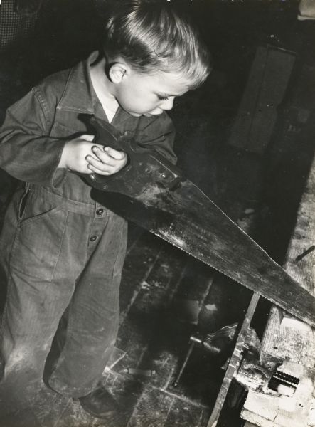 Thorsten Horton, son of Myles and Zilpha Horton, using a saw to cut wood at Highlander Folk School.