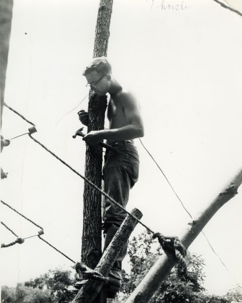Thorsten Horton nailing a post to a structure, as a member of the North South Smokey Mountain Work Camp in Tennessee.
