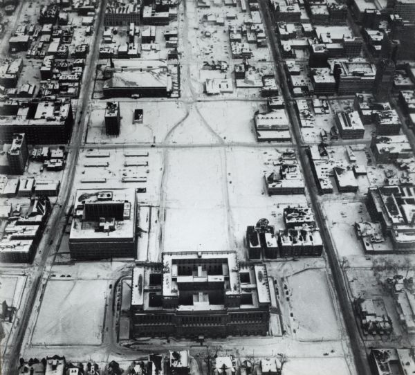 Aerial view of courthouse in center foreground with snow on the ground.