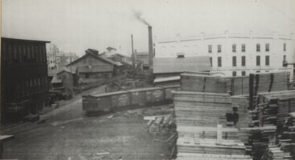 Lumber yard with boxcars and factory buildings in the back. Made while factory was under protection of the State Militia during the first general labor strike in Milwaukee.