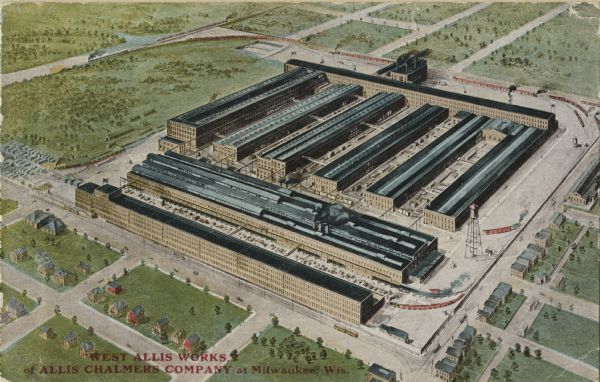 Aerial view of the factory surrounded by fields, roads, and several houses, as well as the railroad tracks that go around the building. Caption reads: "West Allis Works, of Allis Chalmers Company at Milwaukee, Wis."