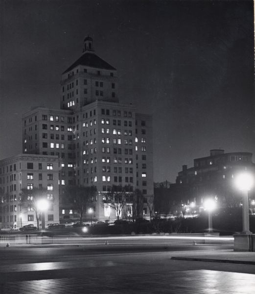 Night view of tower and Memorial Drive. Cars are parked in front of the tower.