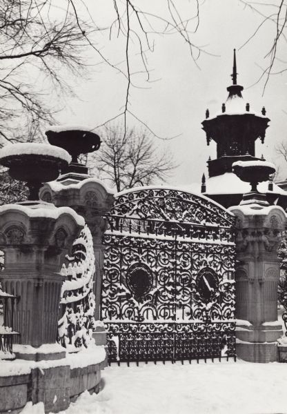 Formerly the home of Alexander Mitchell, at West Wisconsin Avenue and Tenth Street; in 1917 it became the Wisconsin Club.  Entrance gate in the winter.  Wrought-iron gate and fence with stone columns as entrance markers.  High architectural detail is inscribed in the columns.