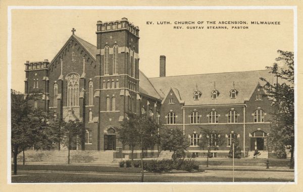 Church on Layton Boulevard between Scott and Greenfield Avenues. Front of church and a side wing is visible from across the road. In the sky area is printed the name of the church, location, and the pastor's name Caption reads: "Ev. Luth. Church of the Ascension, Milwaukee. Rev. Gustav Stearns, Pastor."