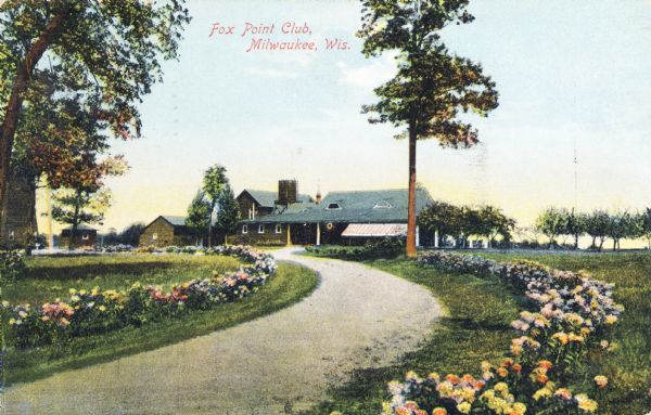 View down curving drive toward a building with a blue roof. The drive is lined by flowers. Caption reads: "Fox Point Club, Milwaukee, Wis."
