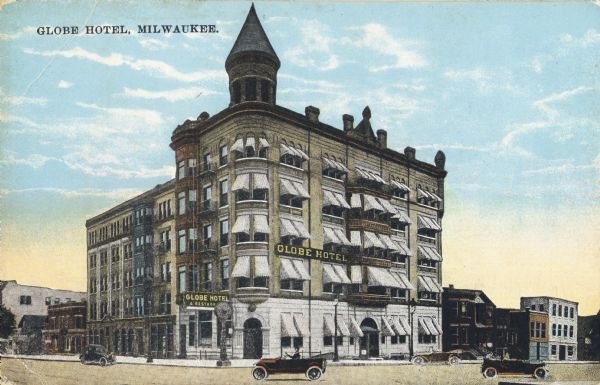 View across intersection toward the corner of Wisconsin Street and Cass Street. The hotel has several floors, awnings on all the windows on one side, and a corner turret. Caption reads: "Globe Hotel, Milwaukee."