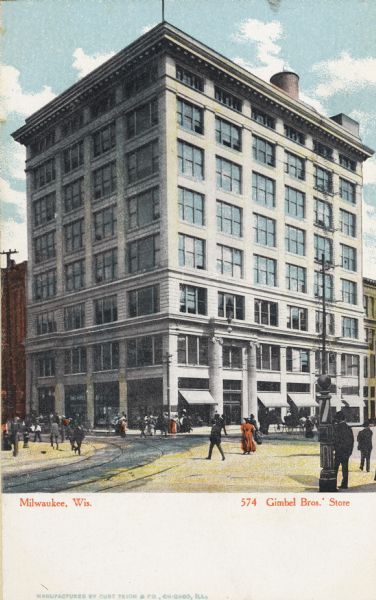 Building on street corner, taken from street level. A man is standing near a barber's pole in the right foreground. The store has eight levels with a water tower on the roof. Pedestrians are crossing the road and on the sidewalks. Caption reads: "Milwaukee, Wis. Gimbel Bros. Store."