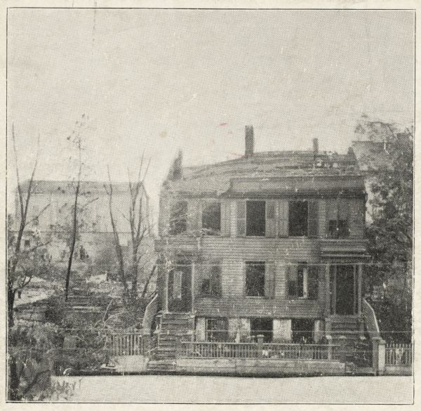 After the fire of Oct. 22, 1865.  The house takes up most of the image to the right, with burnt trees on the left, and a building in the background.  The road is in the lower foreground, and an unharmed tree is on the right.