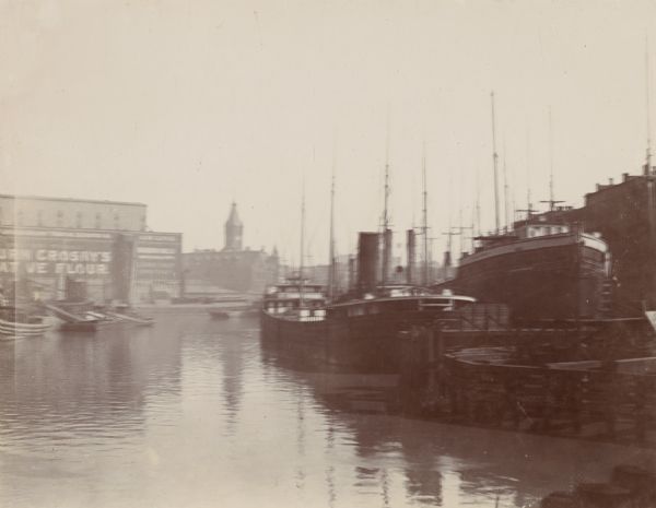 Three boats on right. Left side has two buildings and small boats in fog.