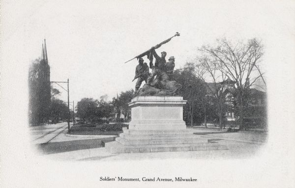 Grand Avenue (now Wisconsin Avenue). A church building is in the background on the left. Caption reads: "Soldiers' Monument, Grand Avenue, Milwaukee."
