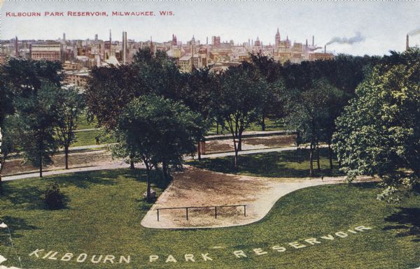 Elevated view of city over Kilbourn Park Reservoir. In the grass is the name of the park in large white letters. Caption reads: "Kilbourn Park Reservoir, Milwaukee, Wis."