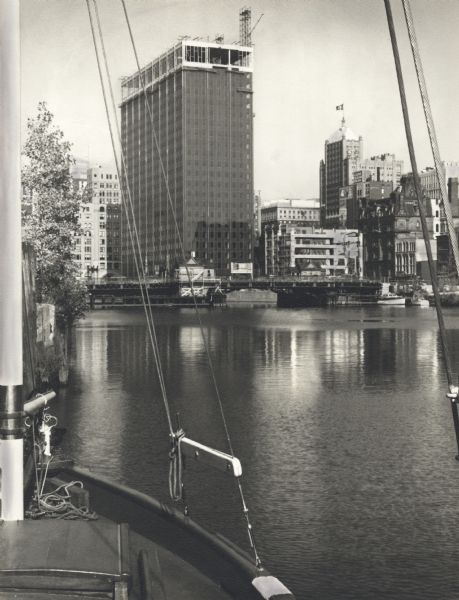 View of building under construction from a boat on the river.