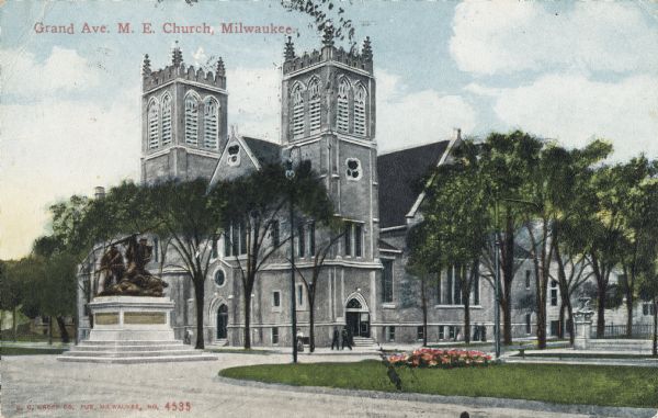 Church on Grand Avenue. A statue is in the median in the foreground. Caption reads: "Grand Ave. M. E. Church, Milwaukee."