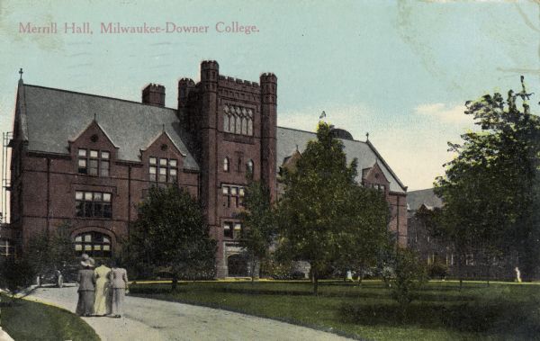 Merrill Hall. The main entrance is across the lawn, and three women are walking down the road towards the building. Caption reads: "Merrill Hall, Milwaukee-Downer College."