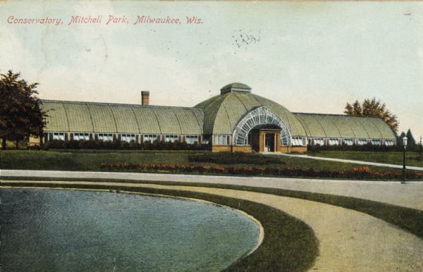 Pond and paths in front of the conservatory. Caption reads: "Conservatory, Mitchell Park, Milwaukee, Wis."