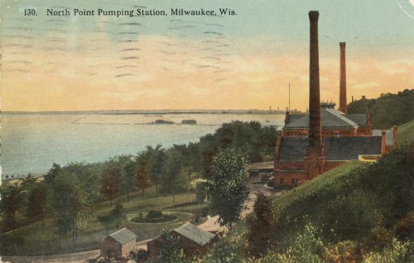 Elevated view from hill toward the building which has two large smokestacks. The Lake Michigan shoreline is on the left. In front is a landscaped area with several smaller buildings. Caption reads: "North Point Pumping Station, Milwaukee, Wis."