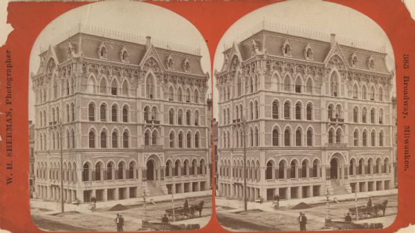 Stereograph; corner of Broad and Wisconsin Avenues. Built in 1870.  E.T. Mix, architect. Victorian details decorate the six story building. A small pile of dirt is in the road. Various people are on the sidewalks, and two horse-drawn carts, one saying "Piano Mover," are in the lower right.