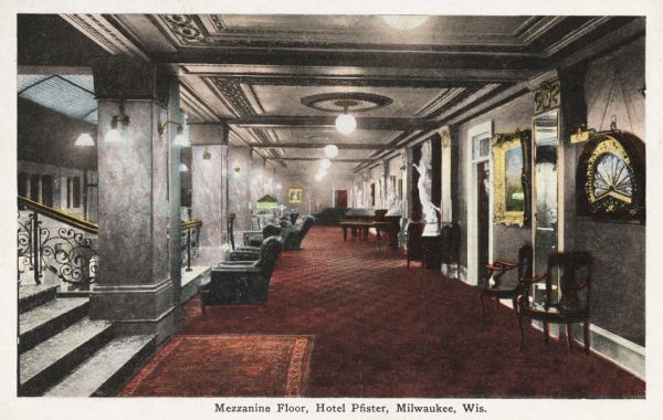 Mezzanine Floor (Interior). A flight of stairs is going up the left side of the image. Several chairs are set up overlooking the balcony.  Various statues and paintings line the wall. Caption reads: "Mezzanine Floor, Hotel Pfister, Milwaukee, Wis."