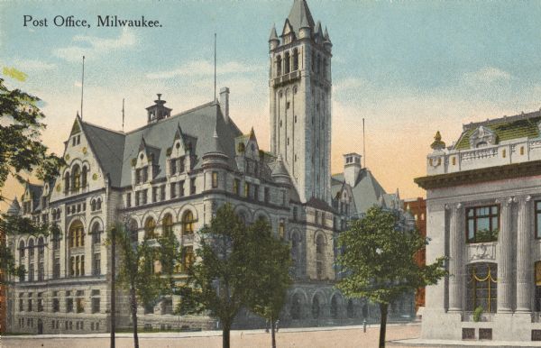 The tower of the building is on the right, with flag poles at various peaks on the roof. On the right across the street is a building with classical style pillars. Caption reads: "Post Office, Milwaukee."