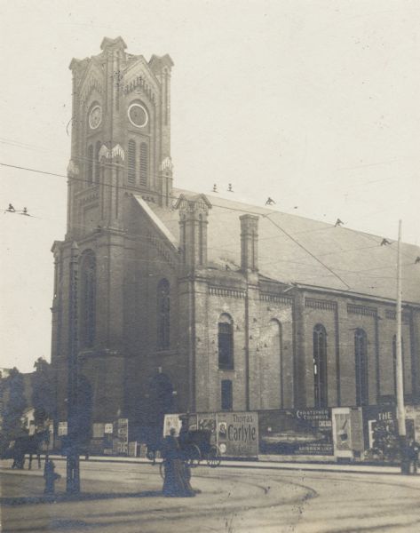 Southeast corner of Second and Sycamore Streets, later the site of a large street railway building.  The picture was taken shortly after the interior was dismantled. A fence full of advertisements separates the grounds of the church from the street. Two horse-drawn vehicles are in the road.