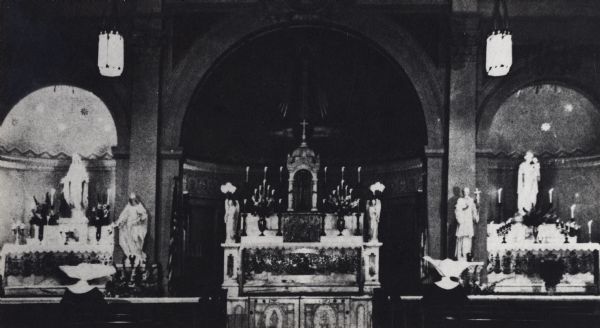 Three alcoves are along a wall; main altar is in the center. Candles decorate the altar areas.