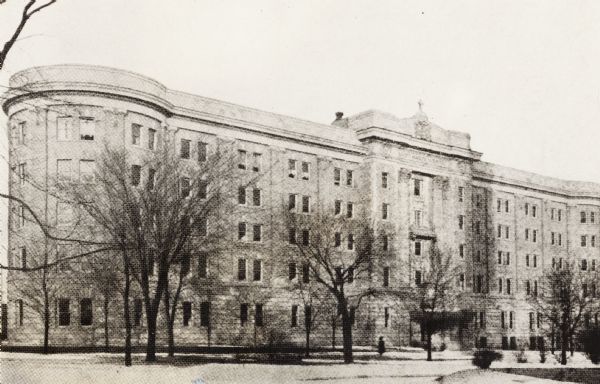 End of wing on left is circular. Trees are in front of hospital in a small park area.