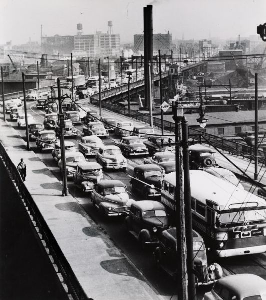 View from the top of a warehouse at the south end of 6th Street. There is a traffic jam on both sides of the viaduct. On the left, one man is walking on the bridge.