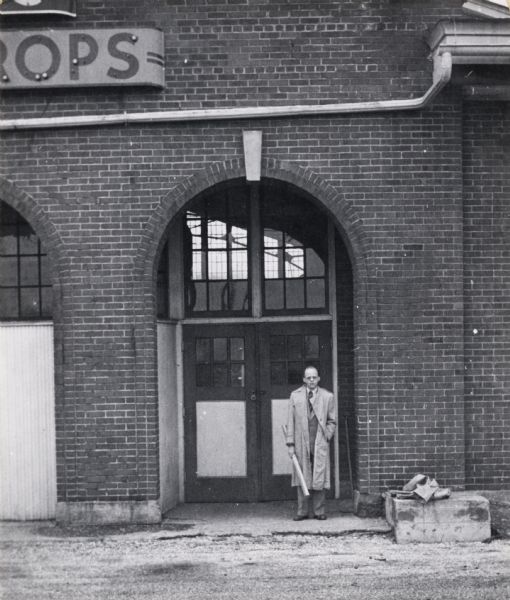 Fruits, Farm Crops building.  A man in a trench coat stands in a doorway.