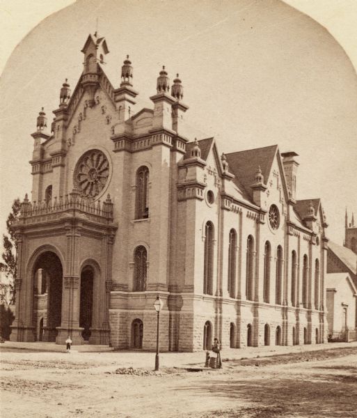 A synagogue at the corner of Broadway and Martin Street. A woman is standing near the street corner, and a boy near the entrance.