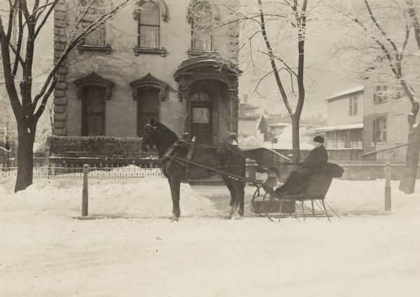 Exterior of house at 525 Jefferson Street.  The first bathtub in Milwaukee, made of tin, was put into this house.  A man in a horse-drawn sled is parked in the front of the house in the snow.

Home of John Thorsen (b. 1820), a lumberman, and Sarah (Kildahl) Thorsen (b. 1832).