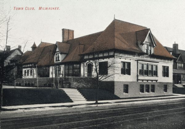 Exterior of building from across the street. A flight of steps leads up from the sidewalk to a side entrance. Caption reads: "Town Club, Milwaukee."
