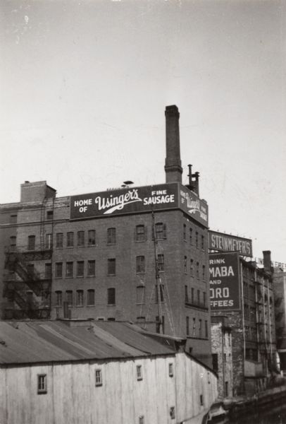 1030 N. Third Street, seen from State Street Bridge. Signs for the building are on the top floor. More billboards can be seen on buildings in the background.