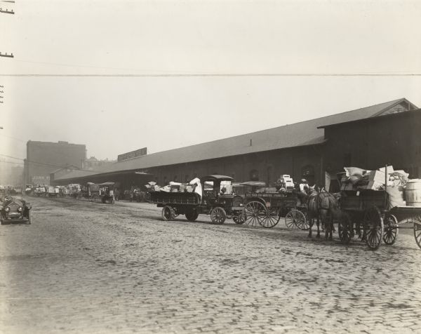 Horse-drawn and motor freight vehicles at the Out-Freight House No. 7 of the Chicago, Milwaukee & St. Paul Railway.
